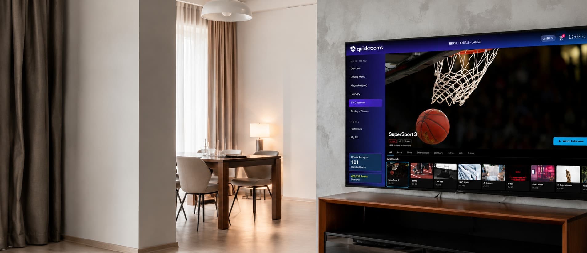 Quickrooms TV on a large screen in a hotel suite, showing live channels alongside the guest's room number and reward points
